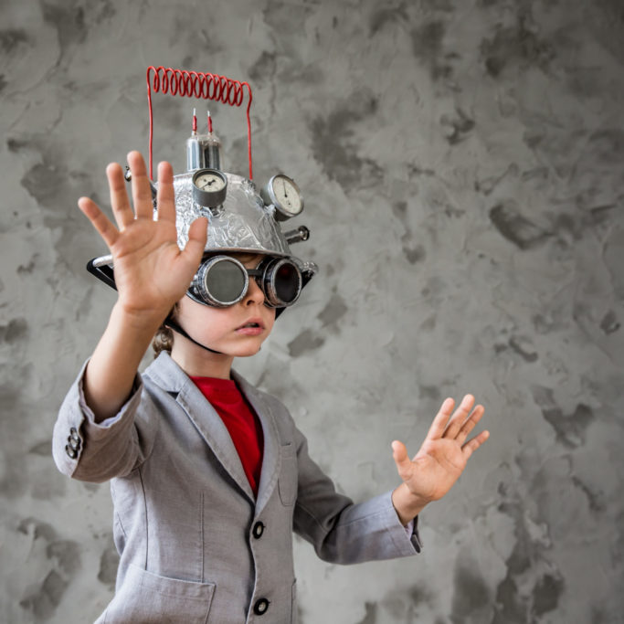 Portrait of young child pretend to be businessman. Kid with toy virtual reality headset in modern loft office. Success, creative and innovation technology concept. Copy space for your text